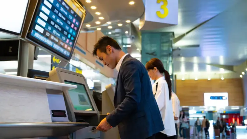 Professionals using check-in kiosks at airport