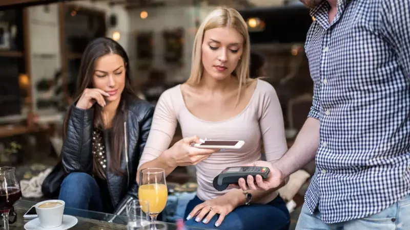 A customer paying at a restaurant with NFC