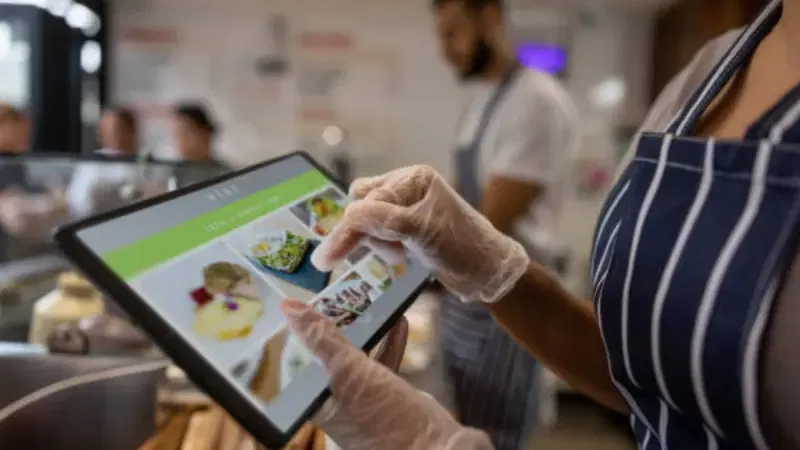 A restaurant employee using POS software