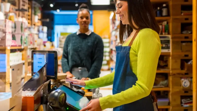 A shop owner using a POS Cash register