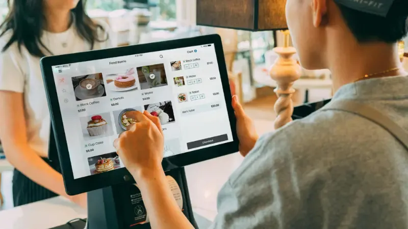 A shopkeeper confirming the order of a customer on the POS system