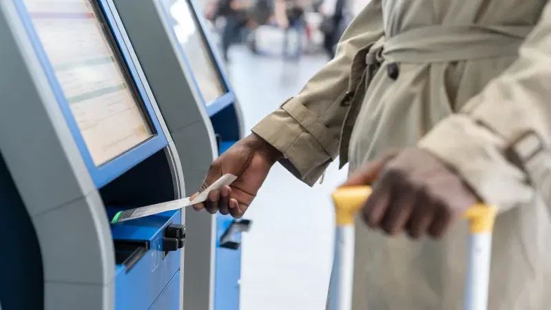 Midsection Of Woman Using Self Check In Kiosk At Airport