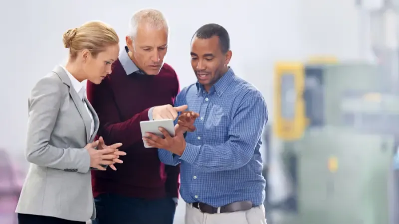 individuals discussing business over a tablet