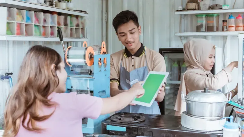 The store owner guiding the customer to pay on mobile