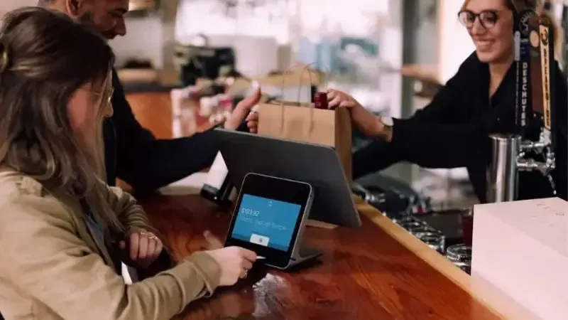 a customer paying at a touch screen cash register