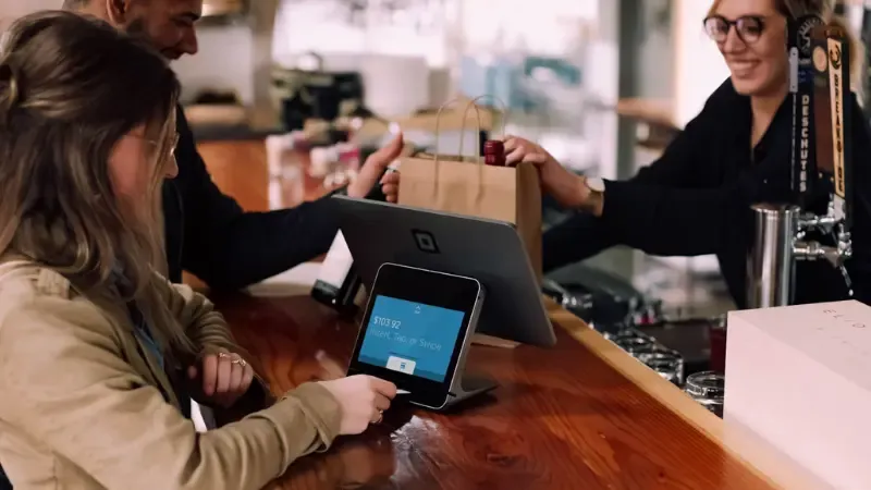 a customer paying at a touch screen cash register