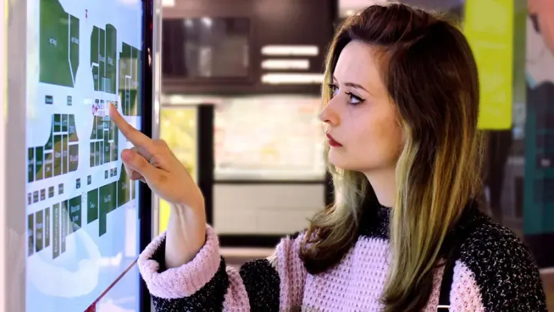 a woman looking at information on an information kiosk