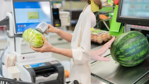 A shopkeeper scanning a product on a self-checkout machine
