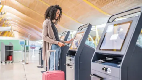 A traveler using a travel kiosk placed in an airport