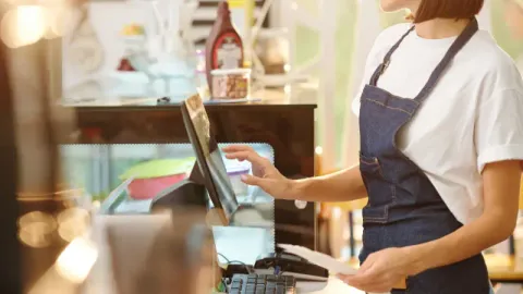 Female Barista Using Cash Register