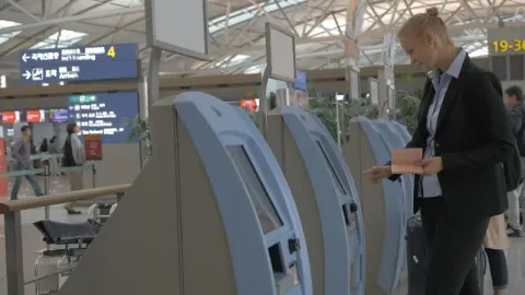 Woman Using Self-Service Machine to Check-in