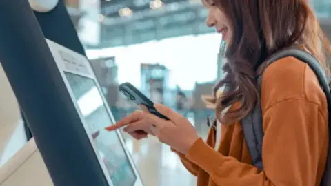 A consumer using a kiosk machine at checkout