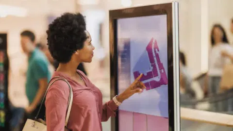 A customer interacting with a digital window display