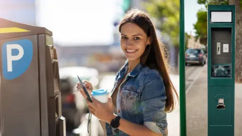 A happy driver using parking kiosk with ease