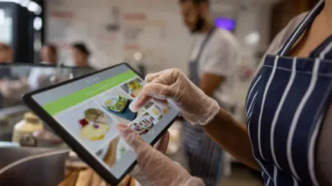 A restaurant employee using POS software