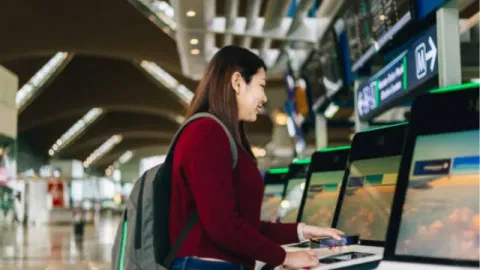 A traveler is using a self-service kiosk at the airport