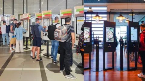 Customers using self-service kiosks in restaurants