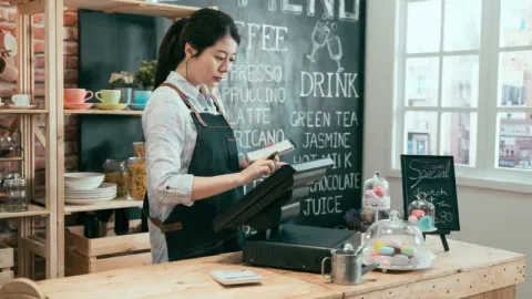 Restaurant owner using cash register