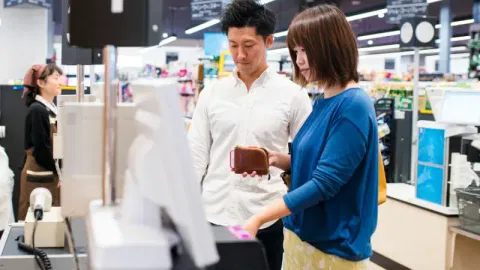 Young adult couple using a self-checkout machine