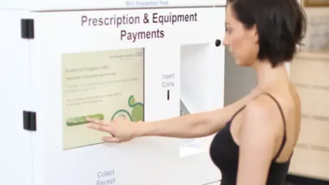 a person using self-service kiosk in NHS hospital