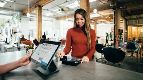 an individual swiping a card at a cash register