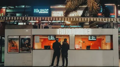 people buying movie tickets from the box office